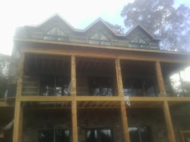 Dormers and porch framing on a large log home under construction — Roof Coating work by our crew in South Plainfield