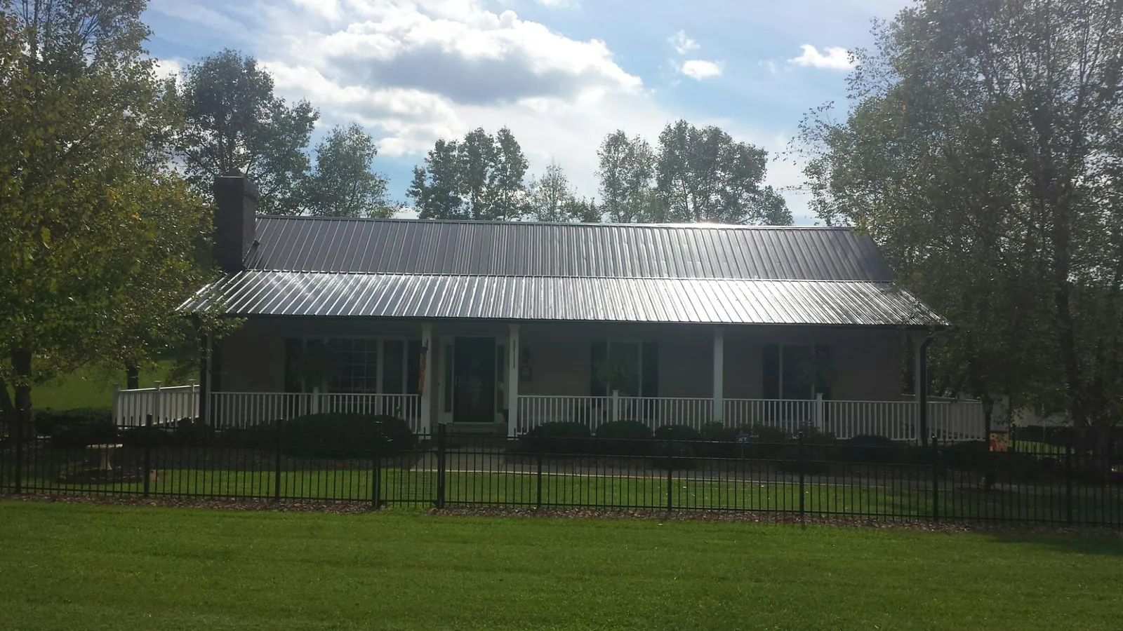 Gray metal roof on a brick ranch with a full width front porch — Gutter Guard Installation work by our crew in South Plainfield