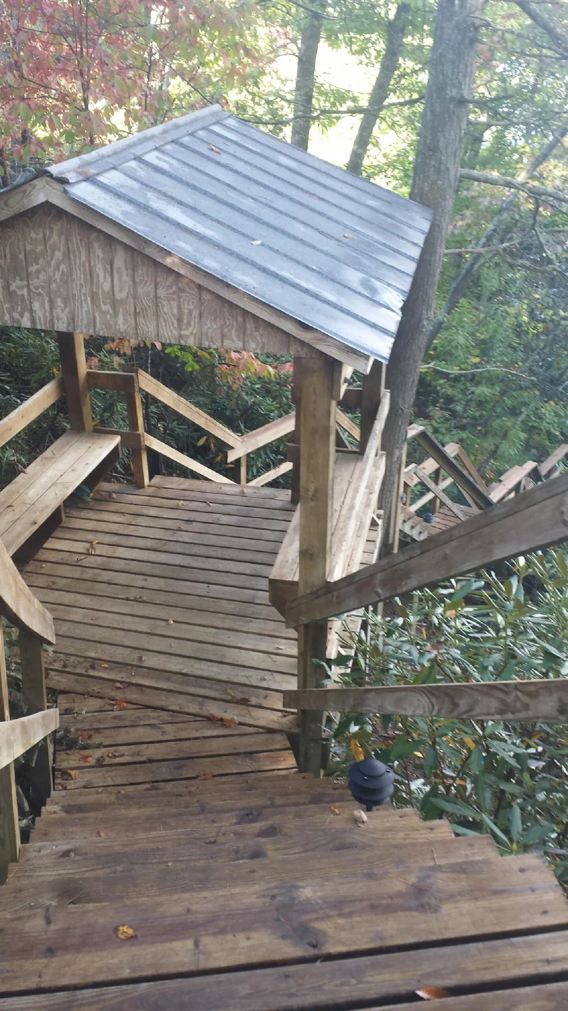 Metal roofed shelter over wooden steps on a wooded walkway — Skylight Repair & Installation work by our crew in South Plainfield